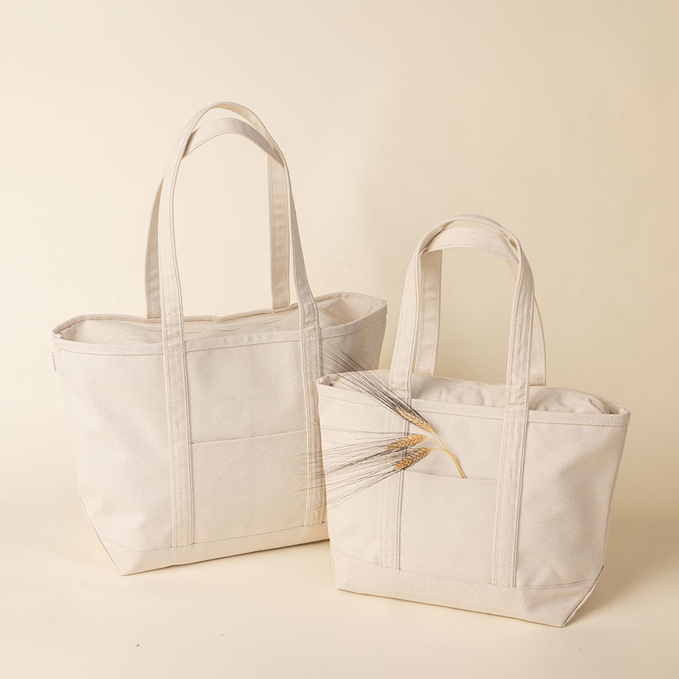 Two natural canvas tote bags on a wooden surface