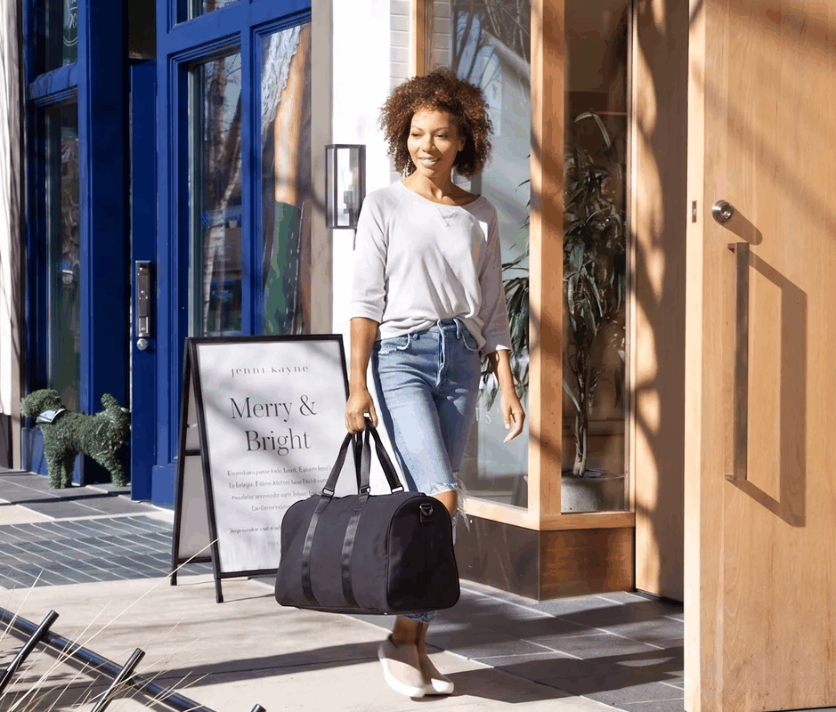 Woman carrying an ActiveSport duffel bag outdoors